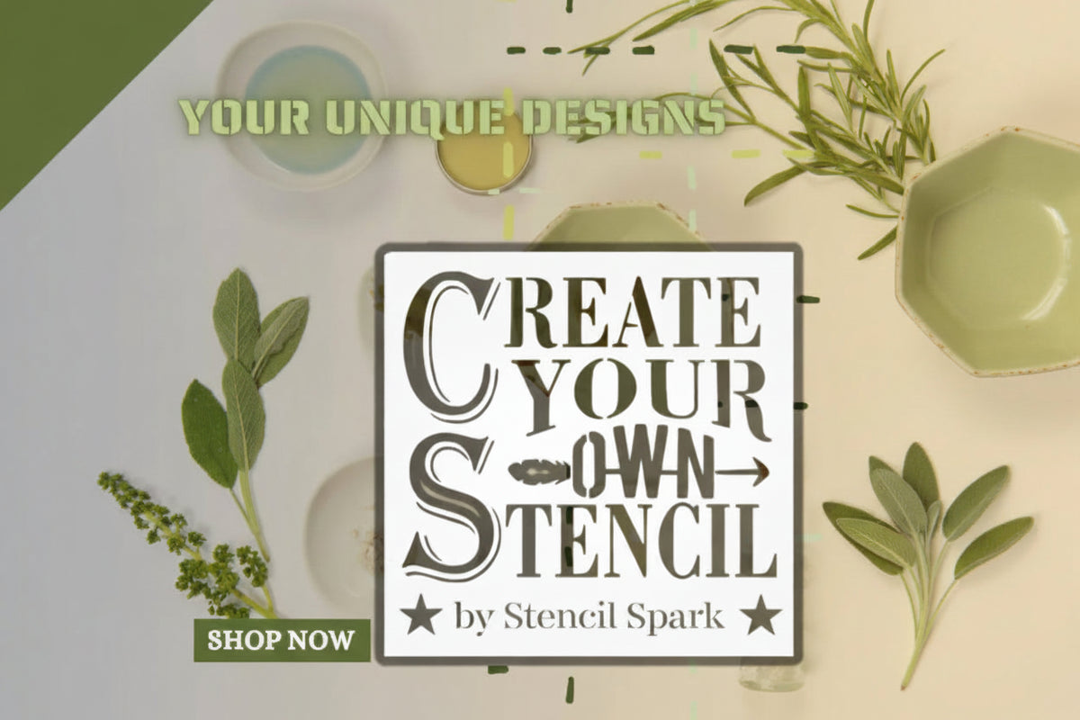 Promotional graphic for a custom stencils service by Stencil Spark, featuring a central white square with the text 'CREATE YOUR OWN STENCIL' and a green 'SHOP NOW' banner. The background is a styled flat-lay with sage leaves, herbs, and paint brushes on a light beige surface.